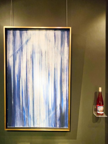 A painting and a bottle of wine displayed at The Harris Gallery