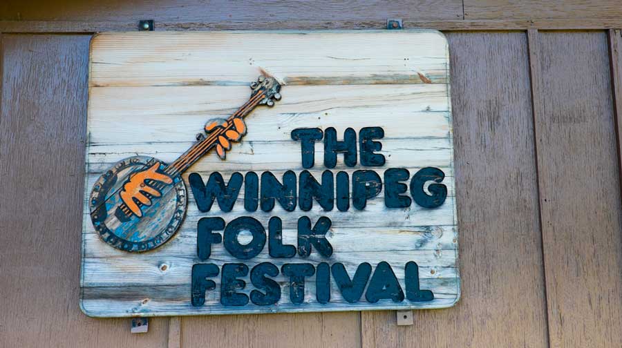 The Winnipeg Folk Festival signage hanging on a wooden wall