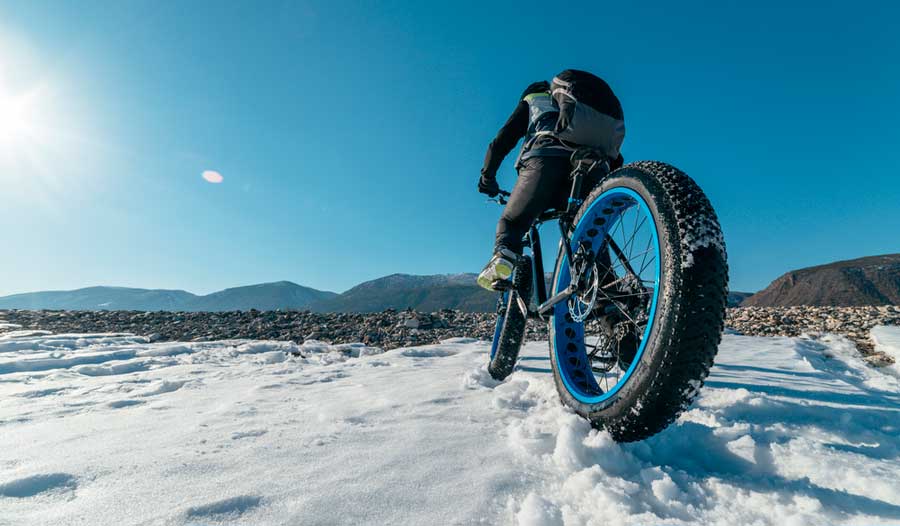 View of a man riding his fat tire bike at winter season