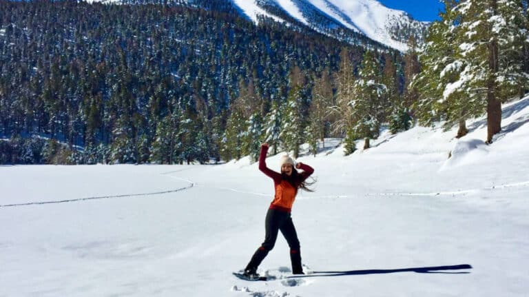 The author McKenna Mobley posing on skis on a snow covered mountain