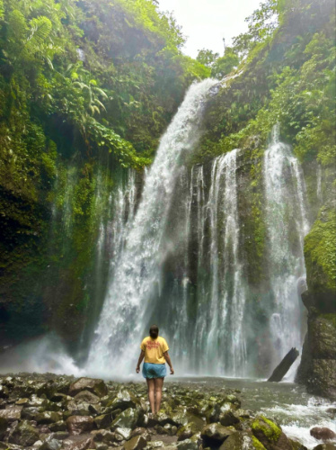 A woman admiring the scenic Tiu Kelep Waterfall