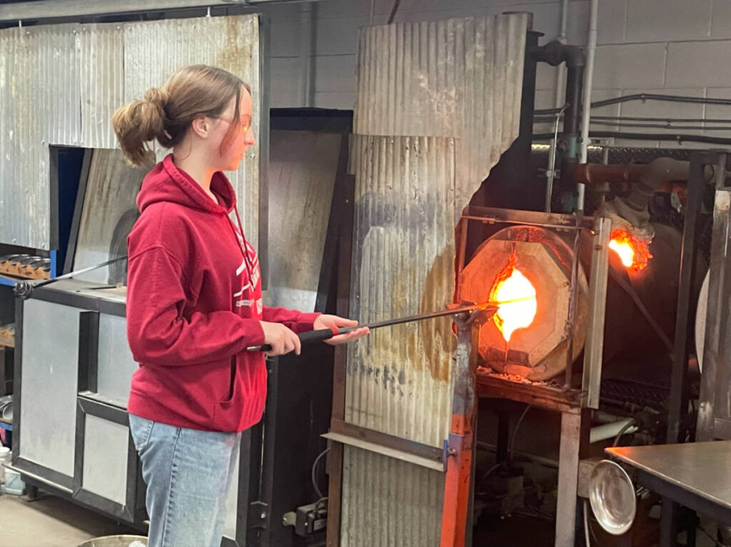 Laura's daughter creating a glasswork at the glassblowing studio