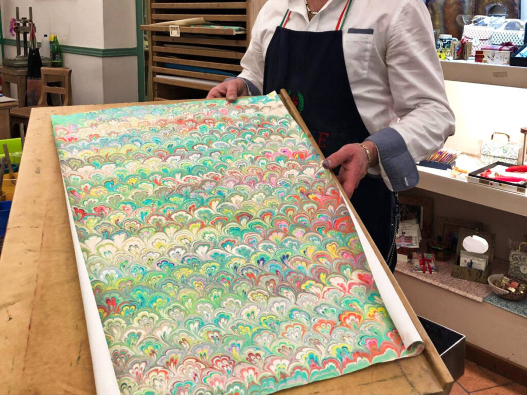 A woman shoeing a dyed paper inside the shop