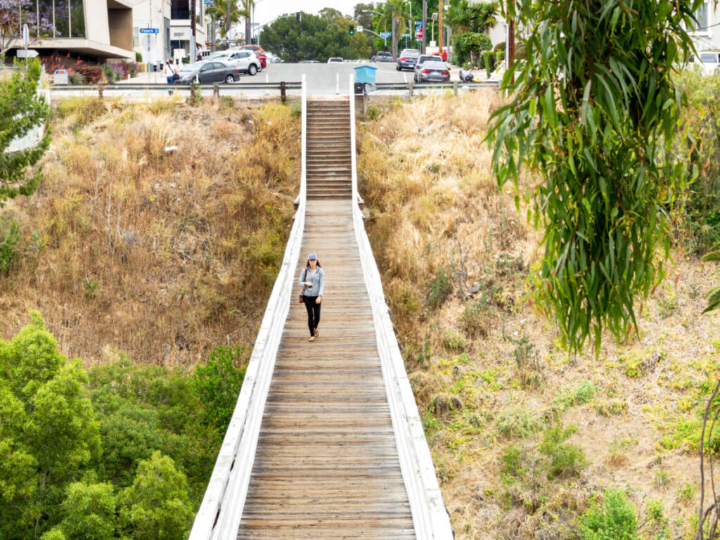 A woman walking across the Quince Street Bridge