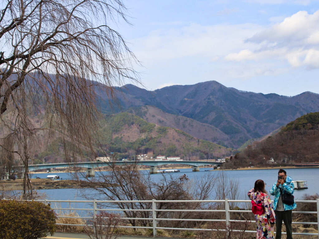 A man taking a photo of the woman wearing a kimono near Lake Kawaguchi
