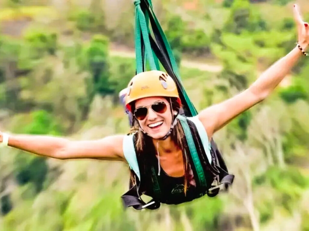 A woman smiling beautifully while ziplining