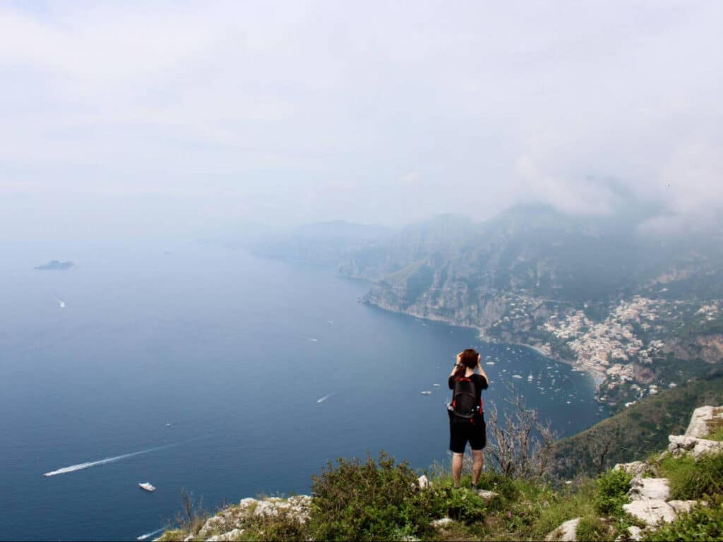 A woman taking a picture of the views of the Amalfi Coast from the Path of the Gods hike