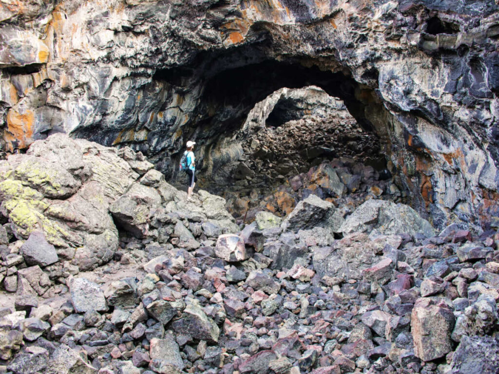 A woman standing at the entrance of Indian Tunnel Cave