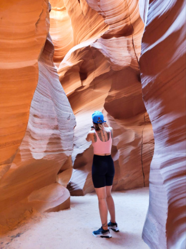 A woman taking a photo in the Lower Antelope Canyon