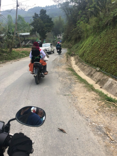 A Woman riding the motorcycle with an infant