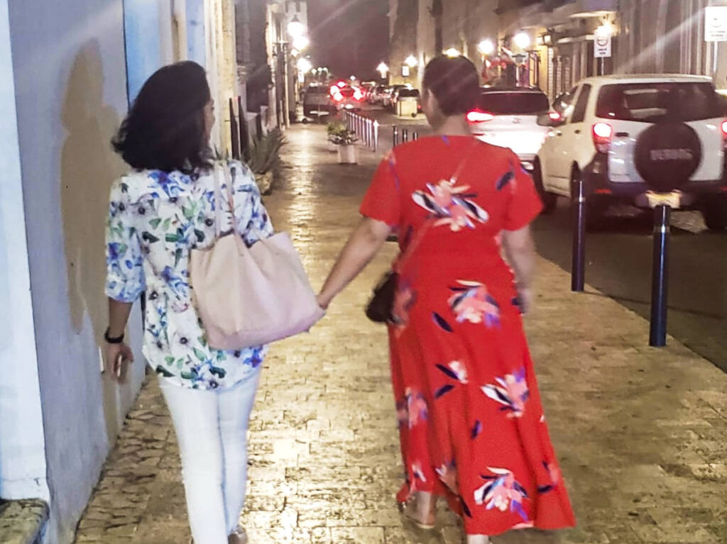 Women Walking while holding hands along la Zona Colonial at night