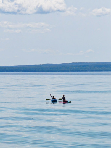 Two women kayaking and paddle boarding on the lake