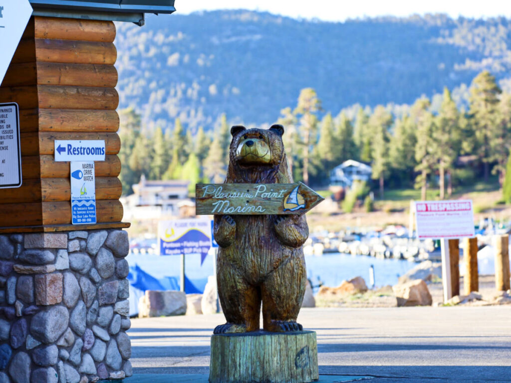 A wooden bear statue holding an arrow at Pleasure Point Marina