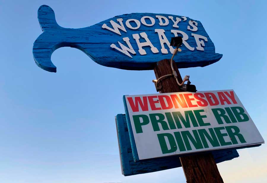 The Woody’s Wharf signage under the dark sky