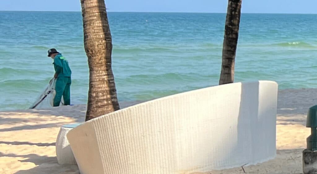 A worker cleaning trash at the Khem Beach