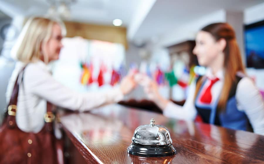 View of a receptionist welcoming a guest at the front desk