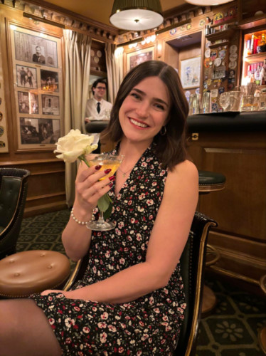 Writer Betty holding a cocktail with white rose at Bar Hemingway