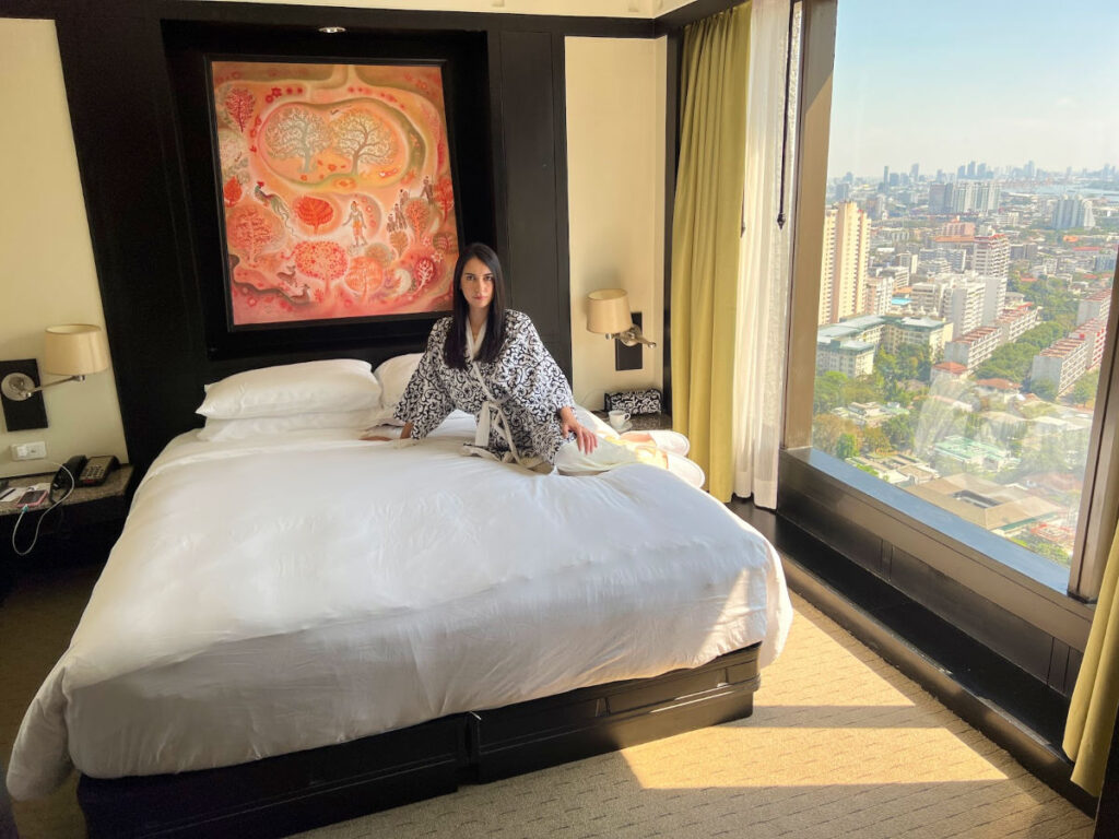 Writer Clara sitting on the bed at the Banyan Tree