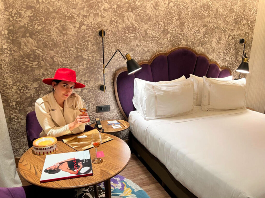 Writer Clara holding a wine in a stylish room of Querencia de Sevilla