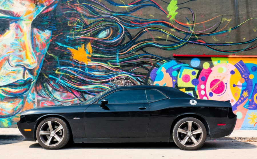 A car in front of the colorful Wynwood Walls