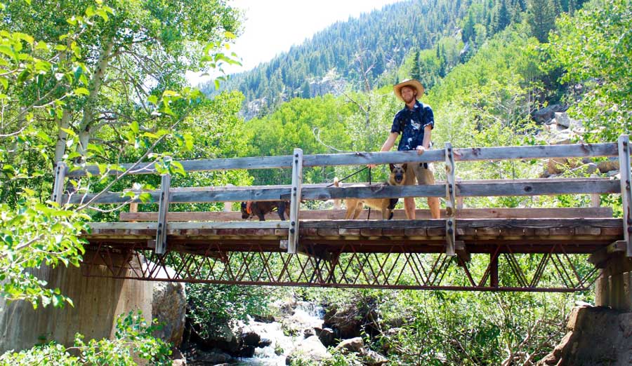 The author's husband and their dogs in a small bridge in Yampa River Core Trail