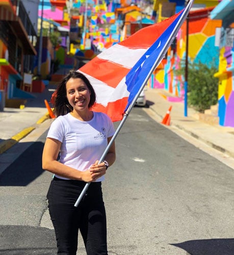 View of the author holding a flag in the colorful street of Yauco