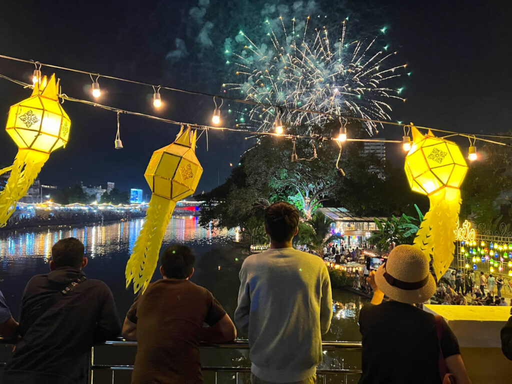 People watching the fireworks over the Ping River during the dual Yi Peng and Loy Krathong festivals