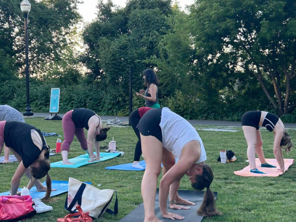 The author Claudicet Pena teaching yoga in a park