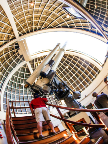 A man looking at the Zeiss telescope in Griffith Park Observatory