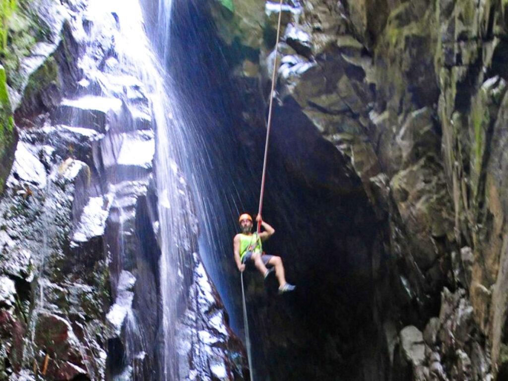 A man waterfall rappelling