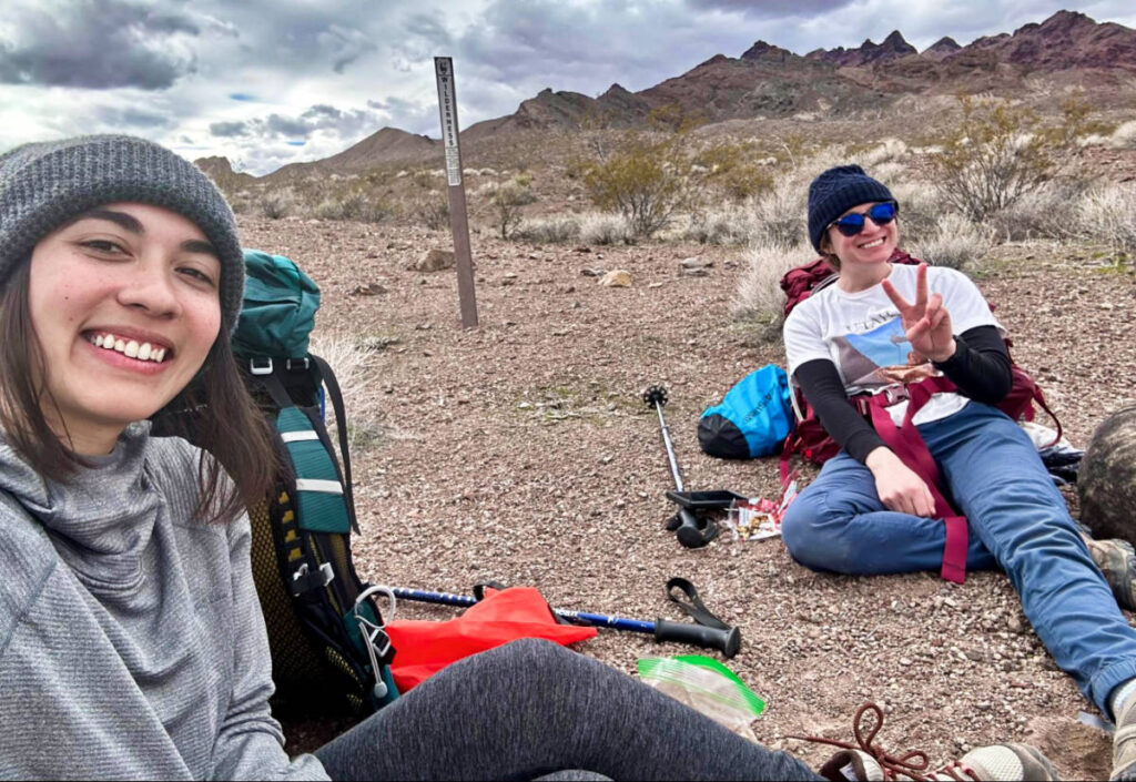 Abigail and Skycie taking a rest from the hike with the mountain view in the background