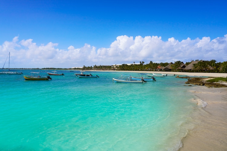 Boats rest in the water just off Akumal Beach