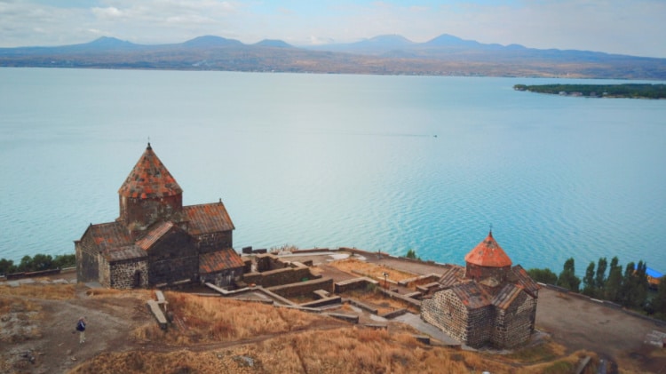 An old church perched on a hill, overlooking the waters of Lake Sevan