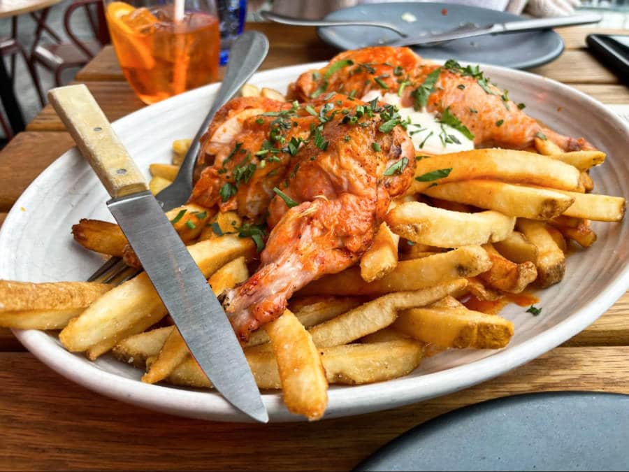 A plate of fries and roasted chicken in avec restaurant