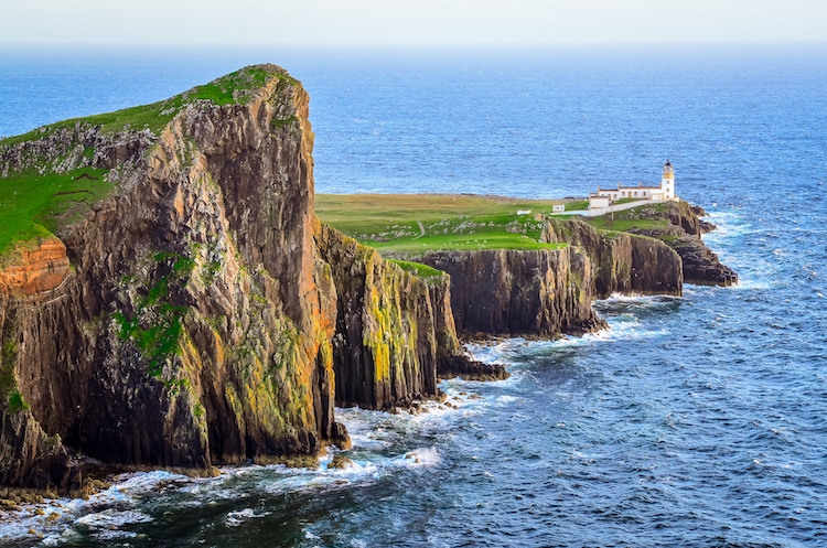 View of Neist Point lighthouse and rocky ocean coastline
