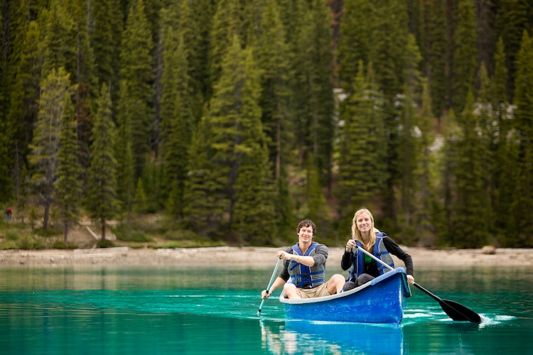 A portrait of two people in a canoe on a glacial lake in Banff National Park