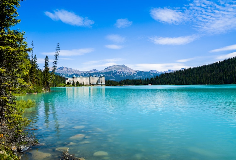 A serene lake with the Fairmont Chateau Lake Louise and mountains in the background