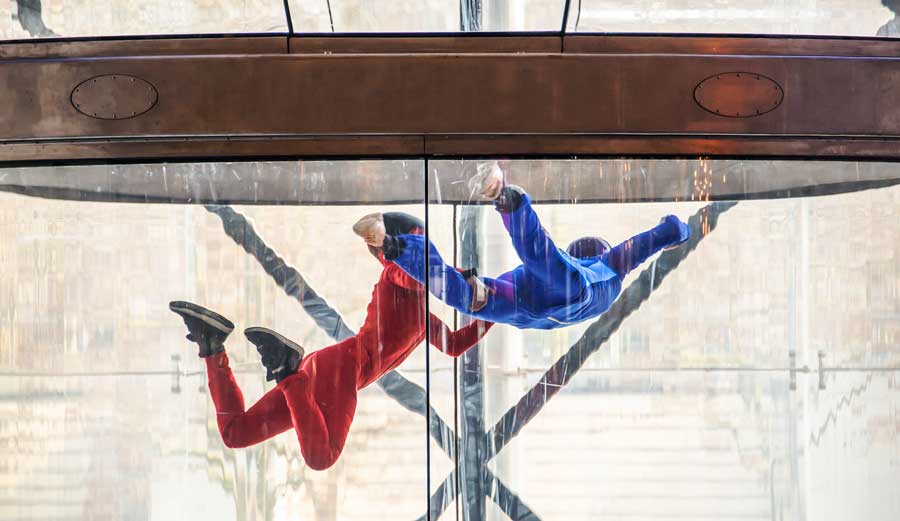 Two people trying out indoor skydiving