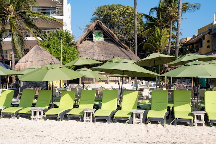 Green loungers sit in front of Lido Beach Bar in Playa del Carmen