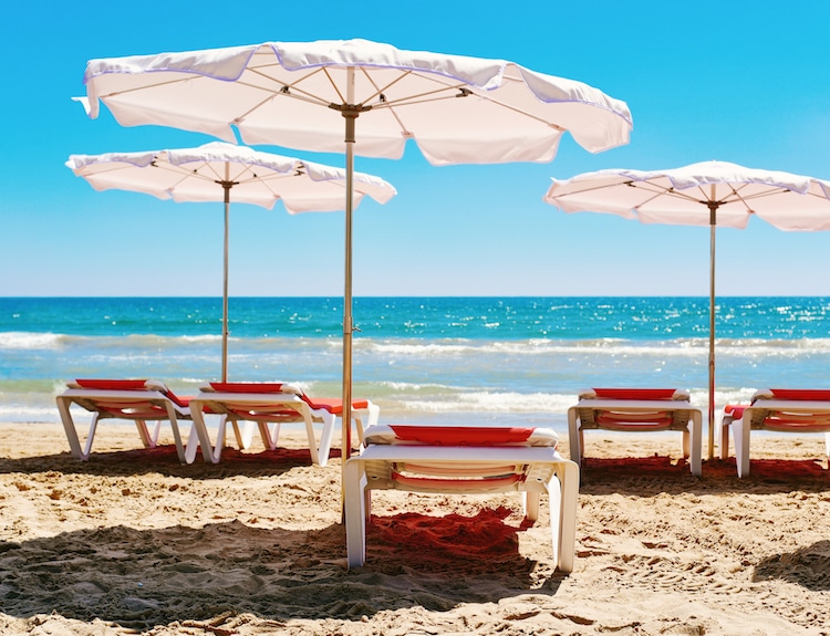 Red lounge chairs line the turquoise waters in the Caribbean Sea