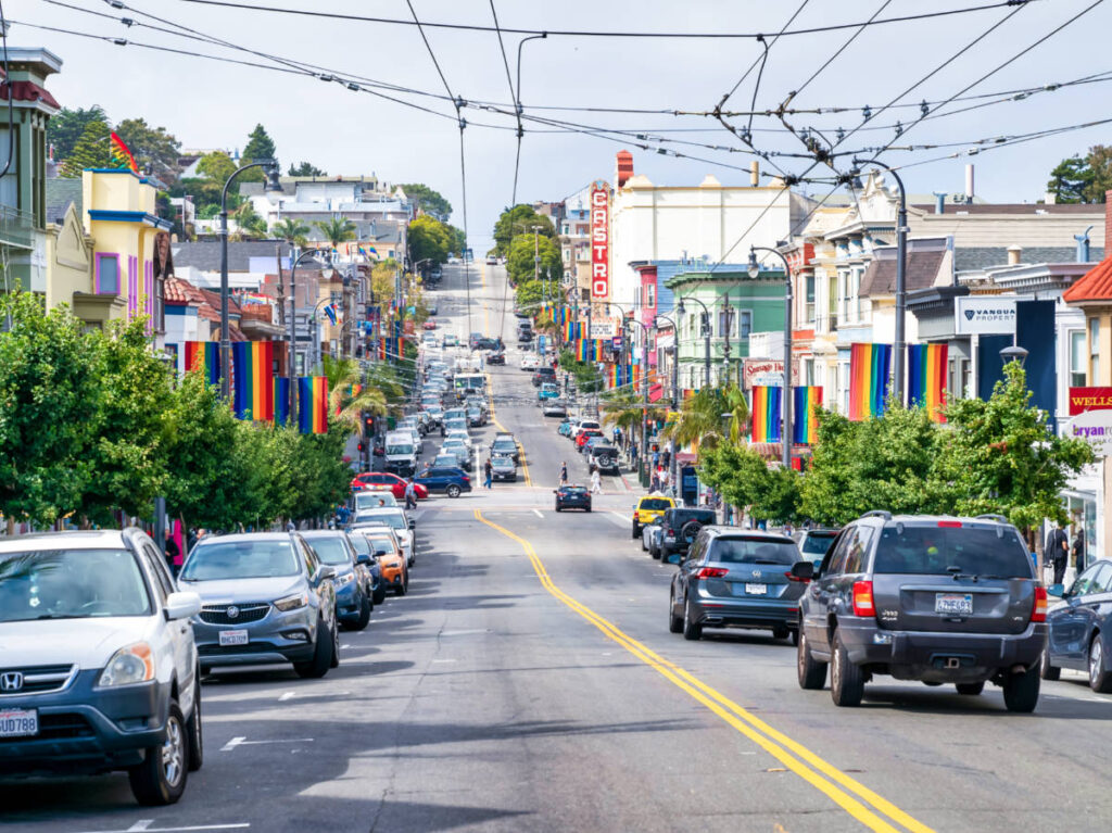 View of the cars parked along the Castro street surrounded by pride flags