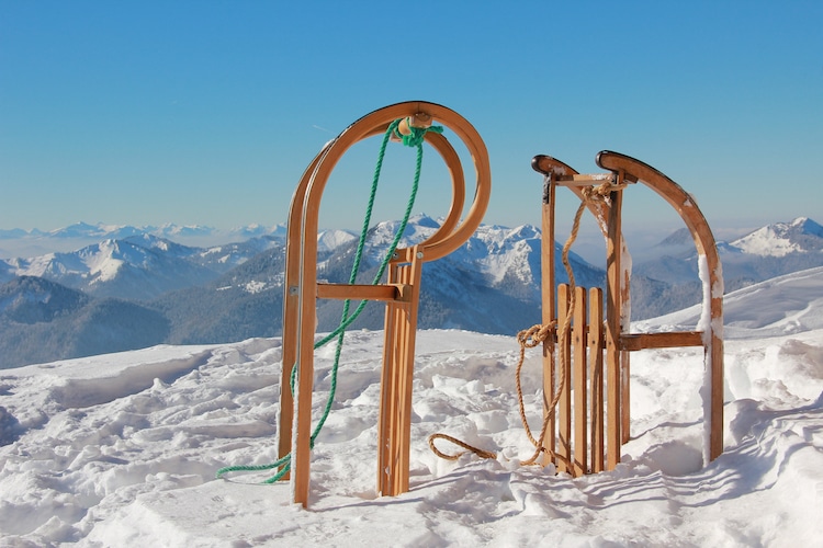 Two toboggans stick out of the snow in a mountain range
