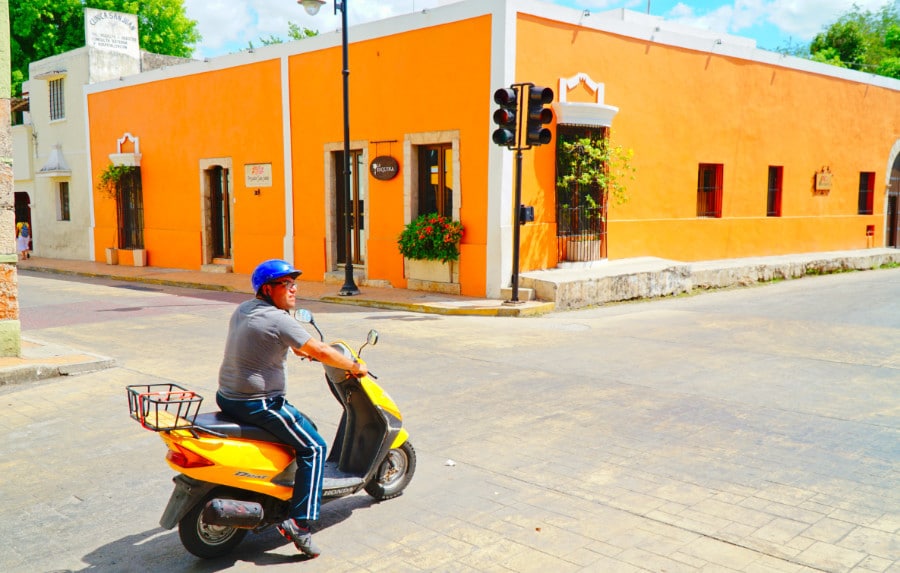 A man on a scooter driving through an intersection