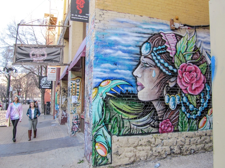 Two women walking and a colorful face of a woman painting